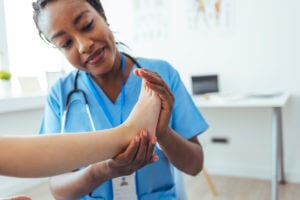 Neat analytical rheumatologist checking patients reflexes