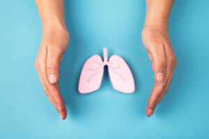 Human lung made of paper and hands isolated on blue background