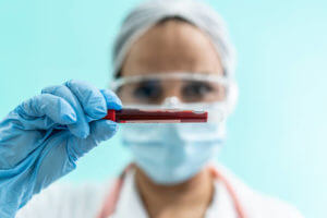 hematologist holding a test tube filled with blood