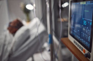 Hospital electrocardiogram, critical care and icu patient with doctor tech in a clinic. Blurred background, heart rate monitor and healthcare technology screen with cardiology and blurred background