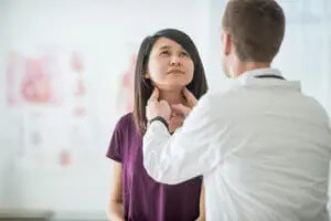 Young woman getting her thyroids checked for hypothyroidism by an endocrinologist.