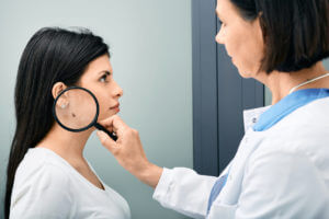 dermatologist examining woman's neck for skin cancer screening