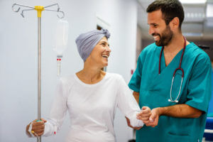 Woman undergoing chemotherapy for cancer is recovering at a cancer center with her male cancer doctor.
