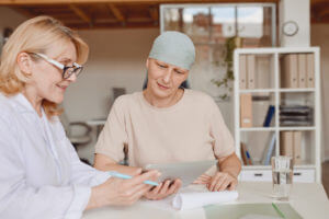 An image of a female cancer doctor consulting with a female patient who has cancer.