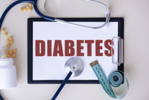 A light background with the word diabetes, a stethoscope, and measuring tape.